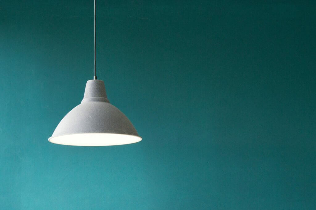 White Light hanging in front of a teal wall. Symbolizes Modern Web Design Simplicity and Focus