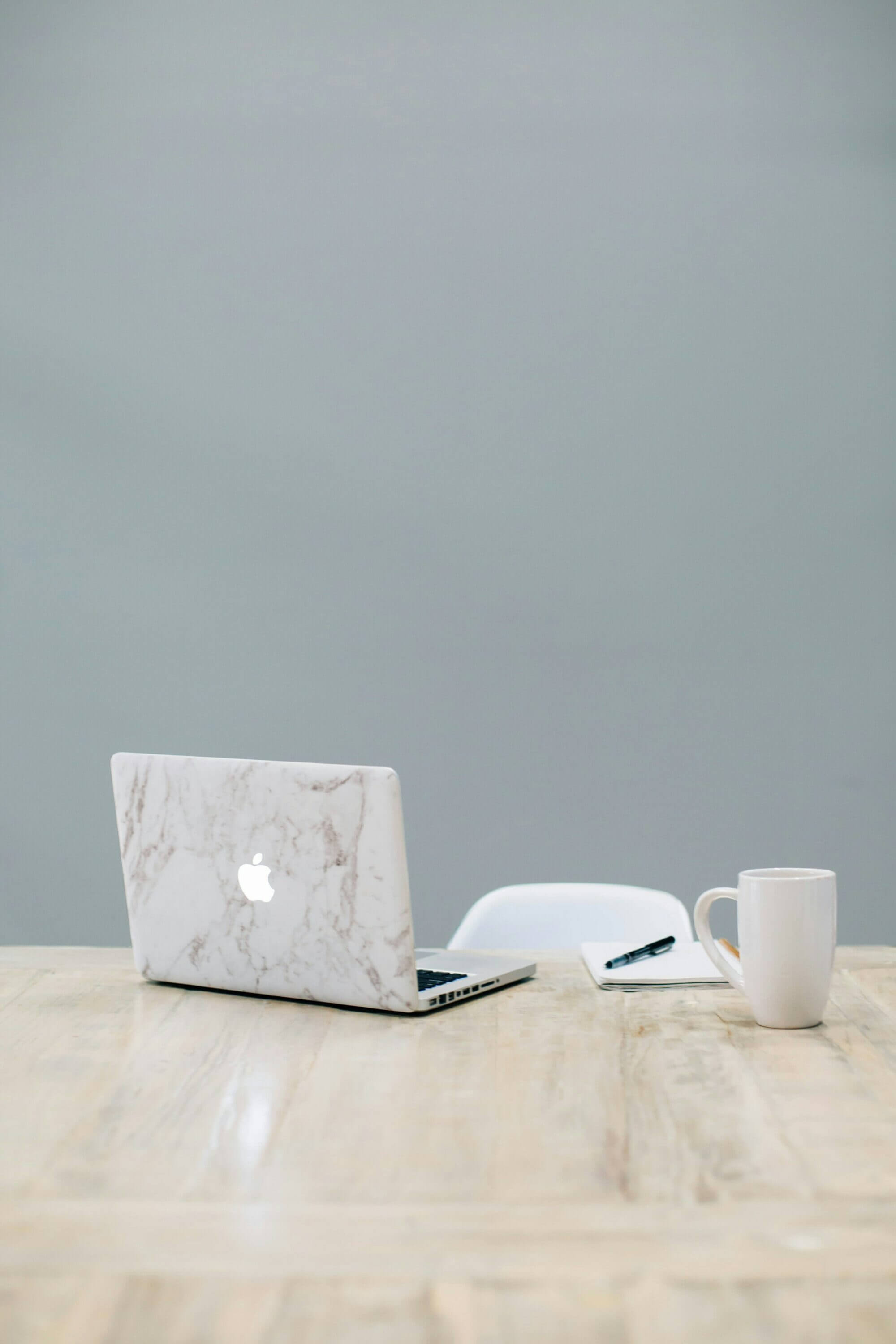 Computer and coffee mug sitting on a desk with no one making the website tweaks that are needed
